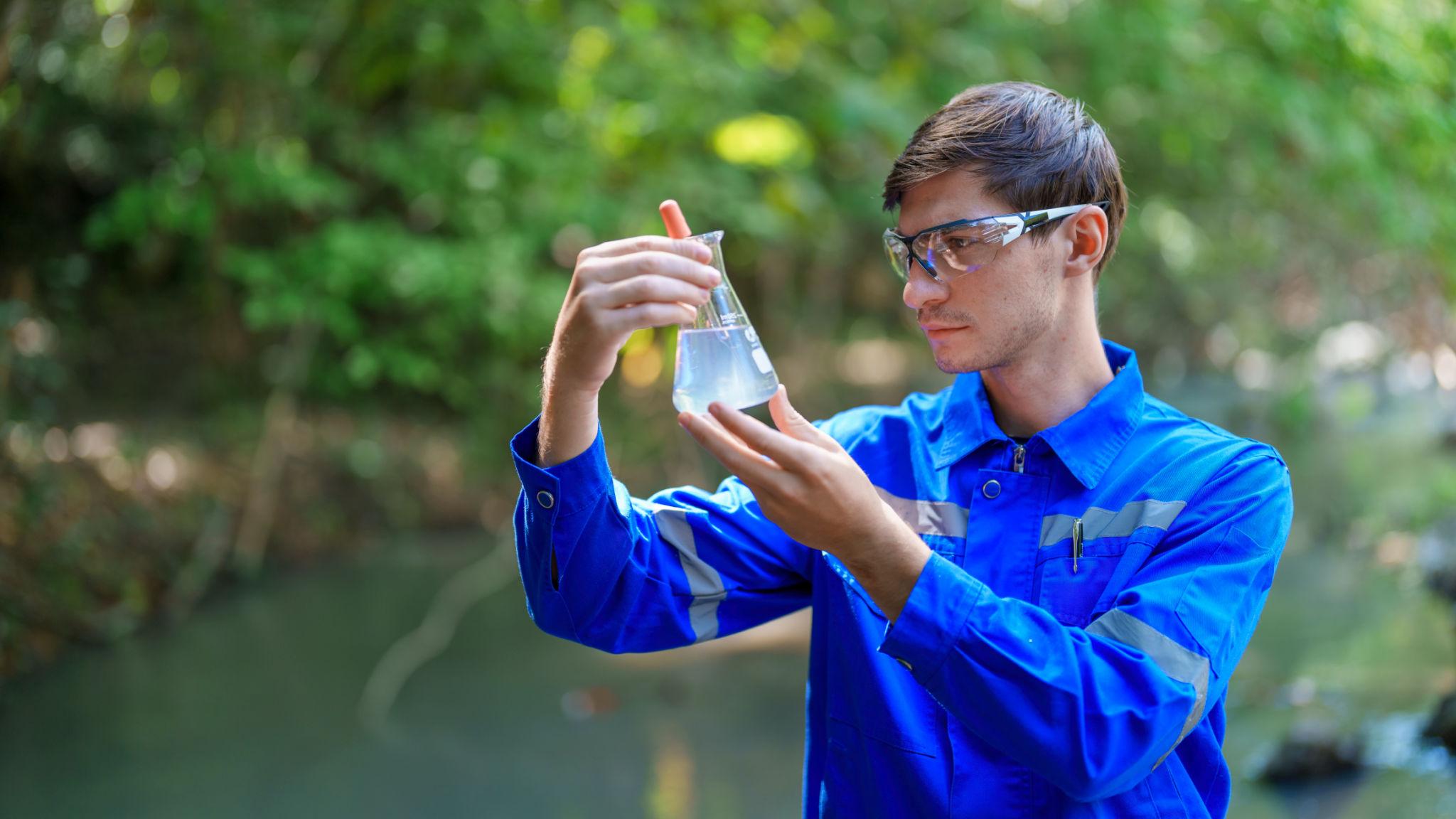 Environmental technician collecting water sample for quality testing on Vancouver Island