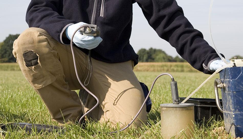 Environmental technician collecting soil sample for contamination testing